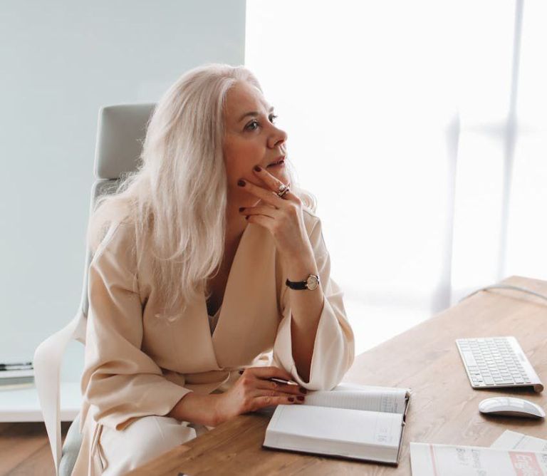 woman sitting by the wooden table while thinking